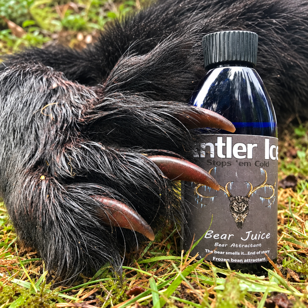 A bottle of Antler Ice Bear Juice Bear Attractant placed next to a bear paw on grass.